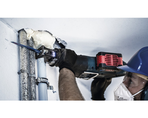 Řemeslník řeže trubku mečovou pilou