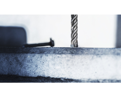 Detailní záběr vrtáku vrtajícího do kovu