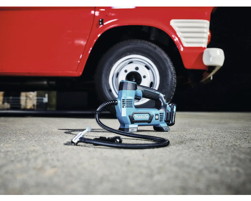 Akumulátorový kompresor Makita před červeným autem