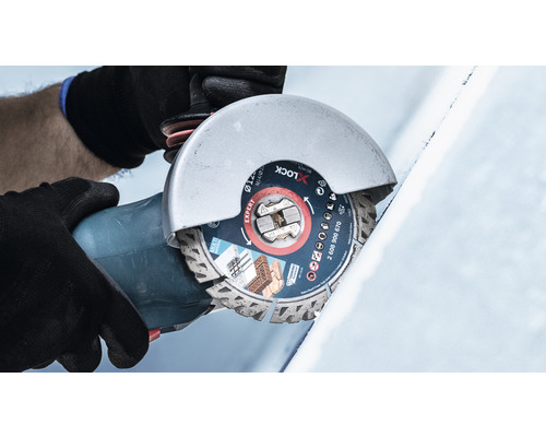 Osoba řeže obrobek úhlovou bruskou s diamantovým řezným kotoučem