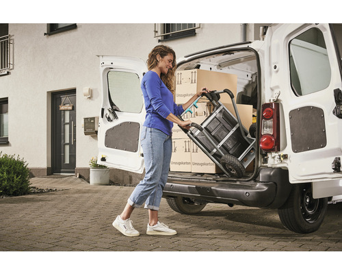 Žena nakládá stěhovací krabice do dodávky pomocí rudlu.