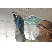 Řemeslník pracuje s multifunkčním nástrojem na stropní desce