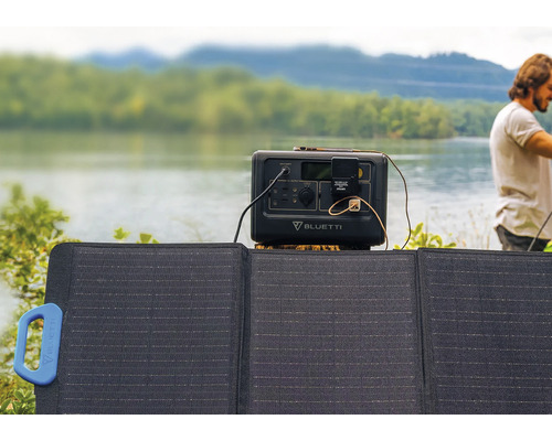 Solární panel a mobilní elektrárna před jezerem