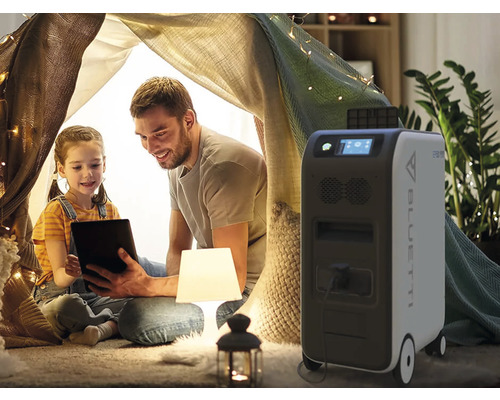Otec a dcera s tabletem ve stanu v domě, vedle mobilní elektrárna Bluetti