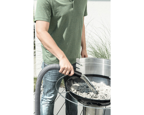 Muž vysává popel z grilu pomocí vysavače na popel