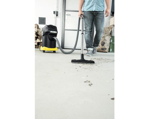 Osoba používá vysavač na mokré a suché vysávání k čištění podlahy.