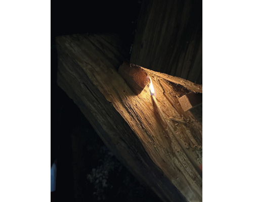 Dřevo na topení je zapáleno zápalkou.