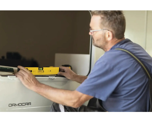 Řemeslník používá vodováhu na kusu nábytku