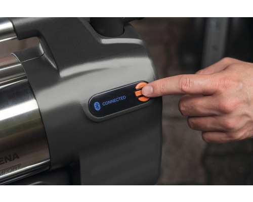 Detailní pohled na zahradní čerpadlo s funkcí Bluetooth a ovládacím panelem, na kterém prst stiskne tlačítko.