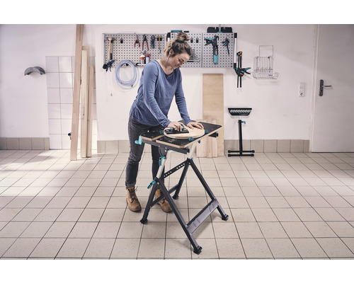 Žena pracuje na ponku s nářadím na zdi