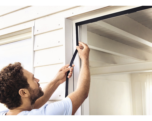 Muž instaluje okenní těsnění