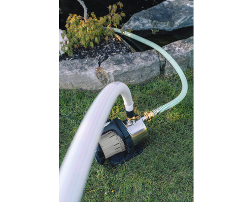 Zahrada s jezírkovým čerpadlem a hadicemi na trávníku