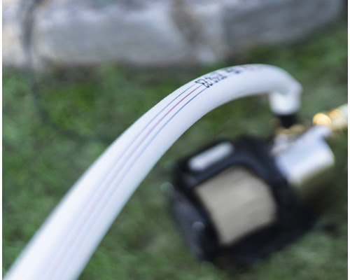 Bílá zavlažovací hadice s barevnými pruhy