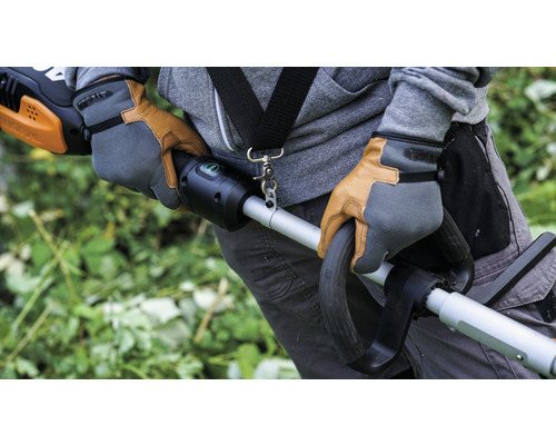 Osoba v pracovních rukavicích obsluhuje vyžínač trávy