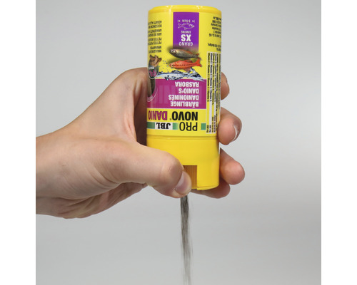 Ruka drží krmivo JBL Novo Danio pro malé ryby