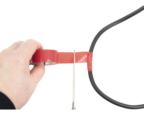 Osoba izoluje napájecí kabel izolační páskou a nůžkami.