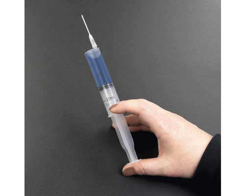 Ruka drží 20mililitrovou injekční stříkačku s jehlou.