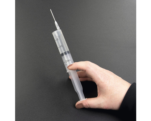 Ruka drží 20mililitrovou stříkačku s jehlou.