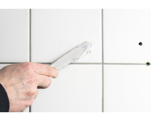 Aplikace spárovací hmoty špachtlí na dlaždice