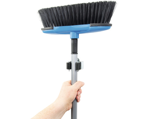 Ruka drží smeták s teleskopickou tyčí