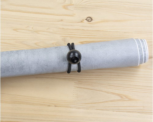 Srolovaná tapeta s gumičkou na dřevěném podkladu