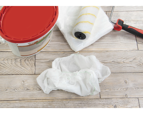 Kbelík s barvou, váleček na barvu, krycí fólie a návleky na boty pro malířské práce.