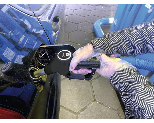 Osoba tankuje naftu do auta na čerpací stanici