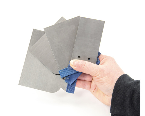 Ruka drží sadu různých kovových špachtlí