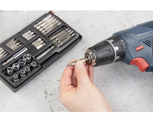 Akumulátorový šroubovák se sadou bitů a ruka vkládající bit