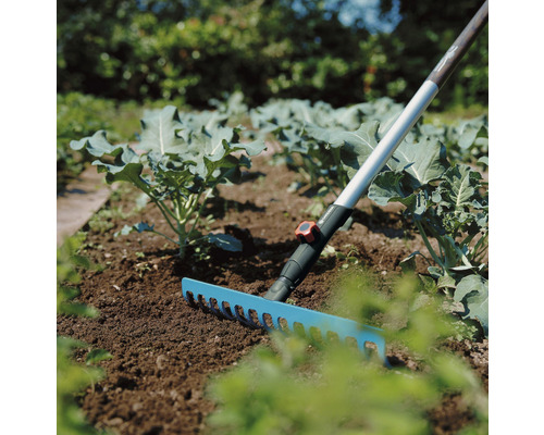 Zahradní scéna s hráběmi na kypření půdy