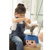 Dívka sype semena do květináče s obličejem