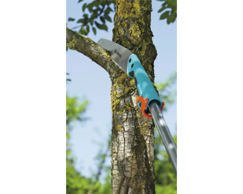 Prořezávací pila řeže větev na stromě.