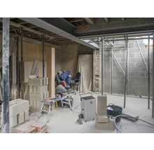 Interiér ve hrubé stavbě se stavebními materiály a stavebním vybavením