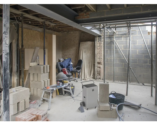 Interiér ve hrubé stavbě se stavebními materiály a stavebním vybavením