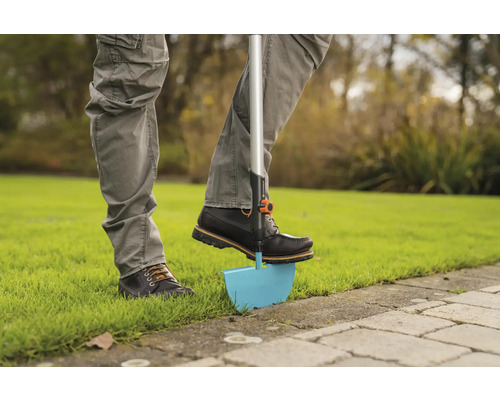 Osoba používá obrubník trávníku na zahradě.