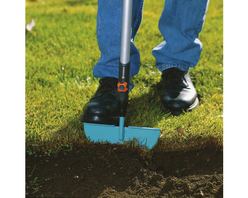 Osoba používá obrubník trávníku v zahradě.