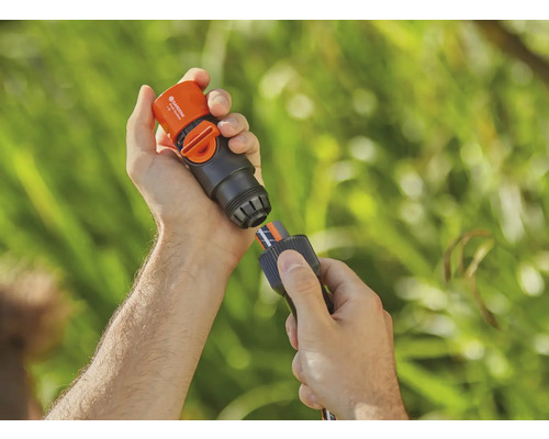 Osoba připojuje Gardena vodní stop konektor k zahradní hadici.