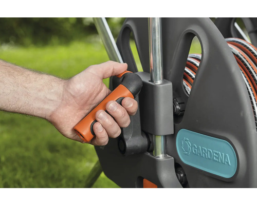 Zahradní hadicový vozík s ruční klikou v provozu