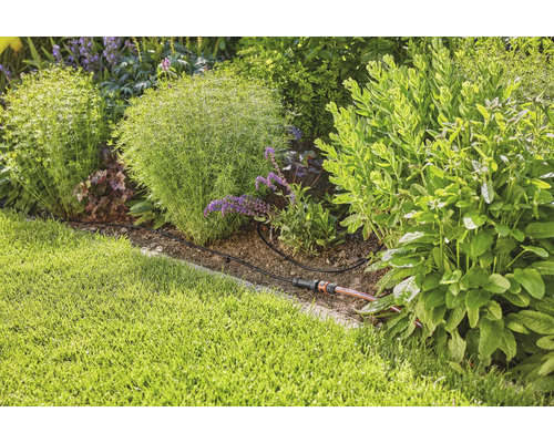 Zahradní zavlažovací systém v osázeném zahradním záhonu.