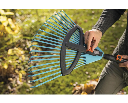 Osoba drží nastavitelné hrábě Gardena