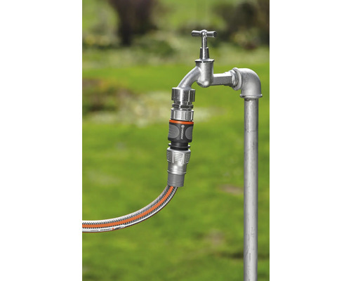 Zahradní hadice připojená k vodovodnímu kohoutku pomocí hadicové spojky