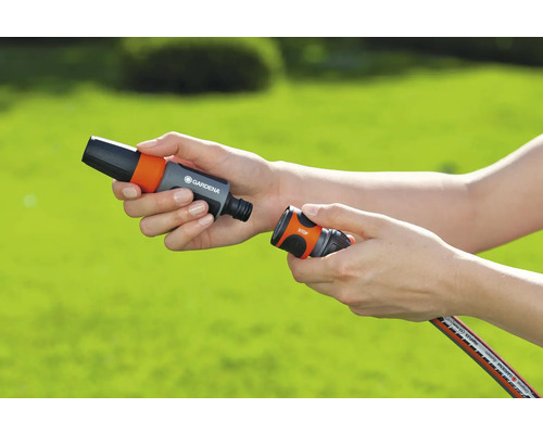 Osoba připojuje spojky zahradní hadice Gardena.