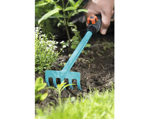 Zahradničení s malými hráběmi v záhonu.