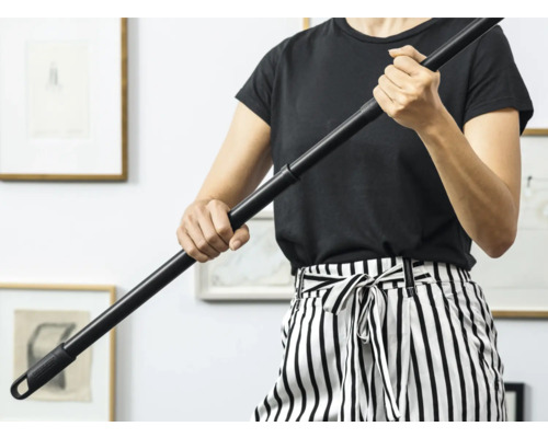 Osoba drží černou násadu na mop.