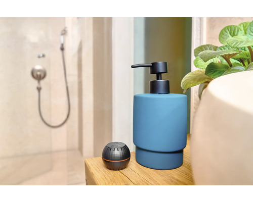 Koupelnová scéna s dávkovačem mýdla a aromaterapeutickým difuzérem na dřevěném stole