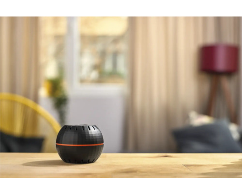 Kulatý osvěžovač vzduchu na dřevěném stole v obývacím pokoji