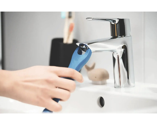 Osoba instaluje vodovodní kohoutek pomocí speciálního klíče v koupelně