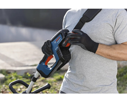 Osoba vyměňuje baterii akumulátorového vyžínače Bosch s popruhem