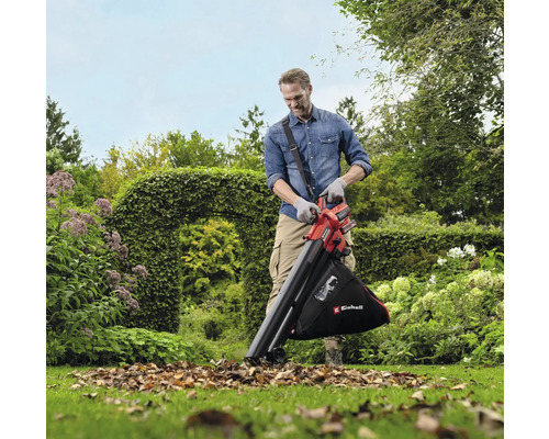 Muž používá na zahradě vysavač listí k odstranění listí.