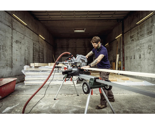 Muž pracuje s pokosovou pilou Metabo v dílně na řezání dřeva.